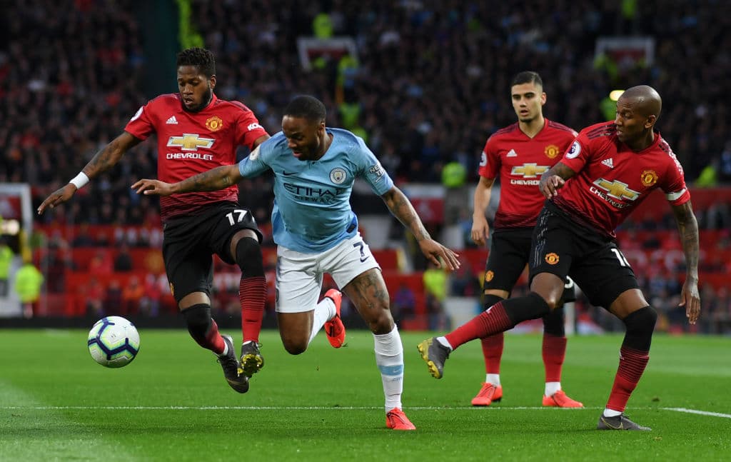 Fred and Ashley Young de Manchester United buscando ejercer presión sobre Raheem Sterling del Manchester City.