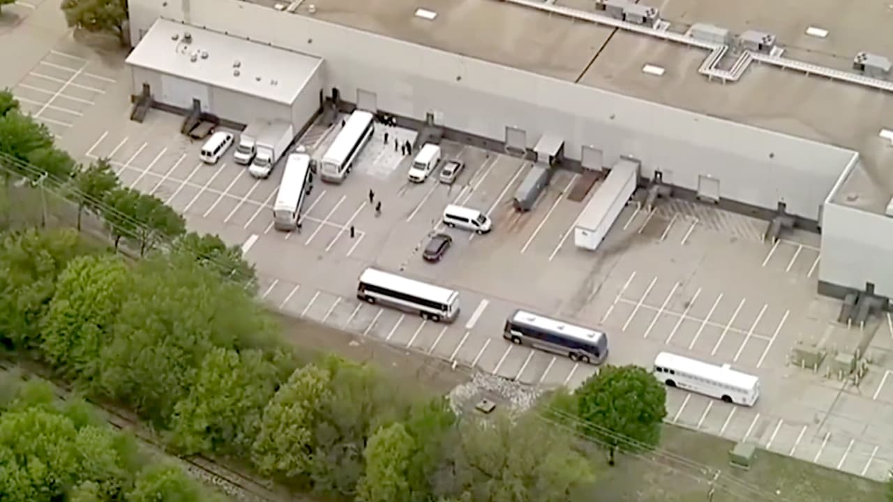 Los agentes de inmigración esposaron a los detenidos en las afueras de las instalaciones de CVE Group, luego los trasladaron en autobuses.