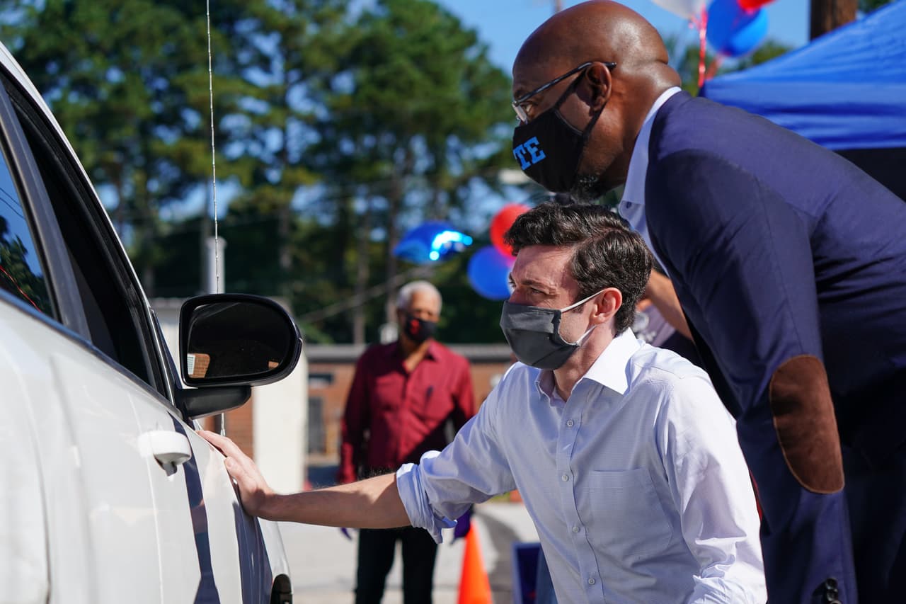 Los candidatos demócratas al Senado de Estados Unidos, Jon Ossoff y el reverendo Raphael Warnock, hablan con un partidario en un evento de campaña en Lithonia, Georgia. Los dos esperan derrocar a los titulares David Perdue y Kelly Loeffler en noviembre.