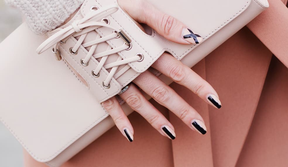 Uñas que están perfectamente coordinadas con el outfit. El trazo de la línea negra le da un twist al manicure. Para evitar trazos imperfectos puedes usar dos cachos de cinta adhesiva que delimiten el grosor de la raya y rellenar con barniz negro. O también puedes usar estampas para uñas. Se vale llevarlas todas iguales o crear diseños diferentes en una o en varias.