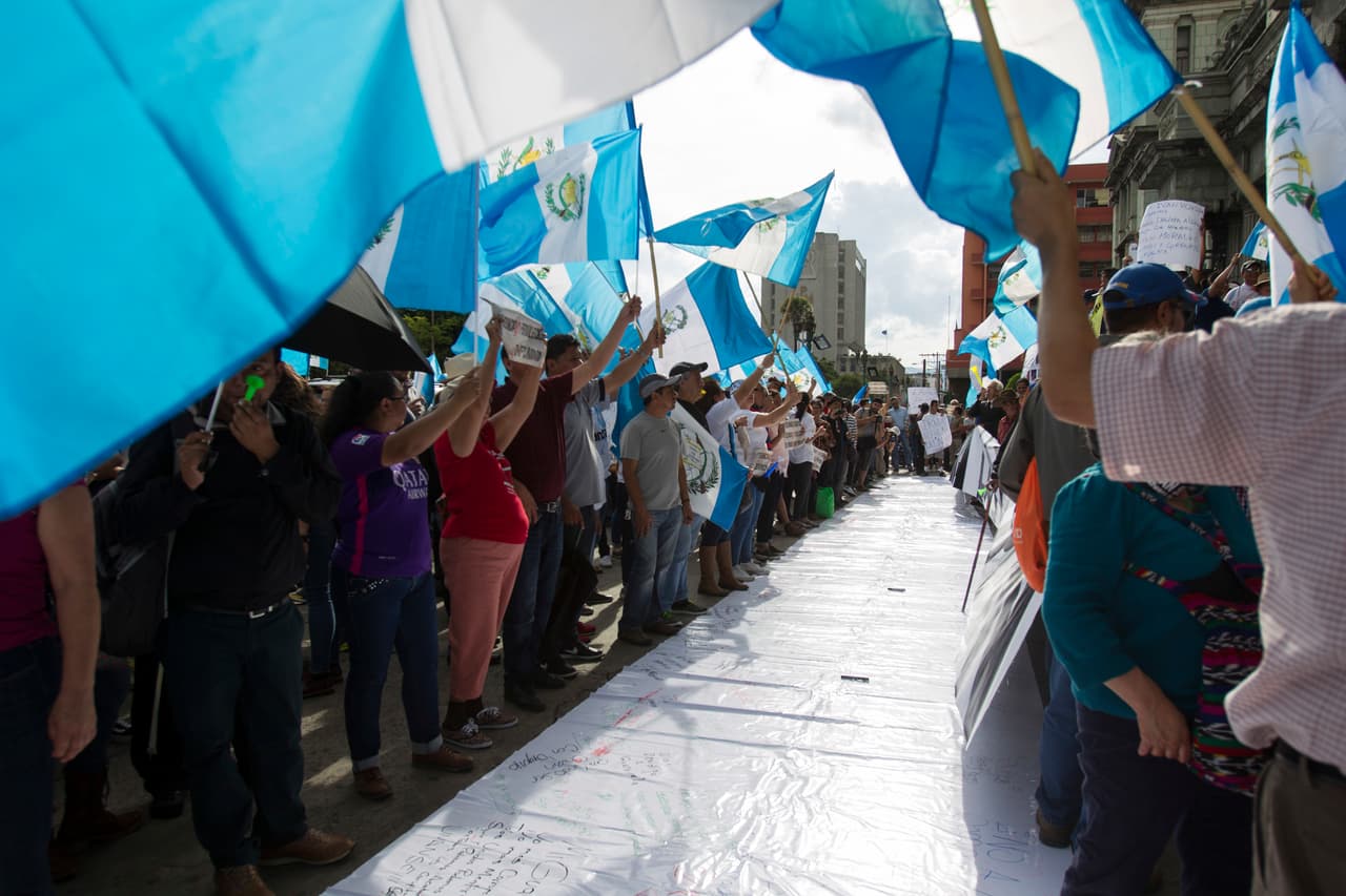 Unas personas se manifiestan en apoyo de Iván Velásquez, titular de la Comisión Internacional contra la Impunidad en Guatemala, en Ciudad de Guatemala, el sábado 26 de agosto de 2017. El presidente Jimmy Morales anunció el domingo la salida del país de Velásquez, después de que este inició una investigación en contra del mandatario por delitos electorales. (AP Foto/Moises Castillo)