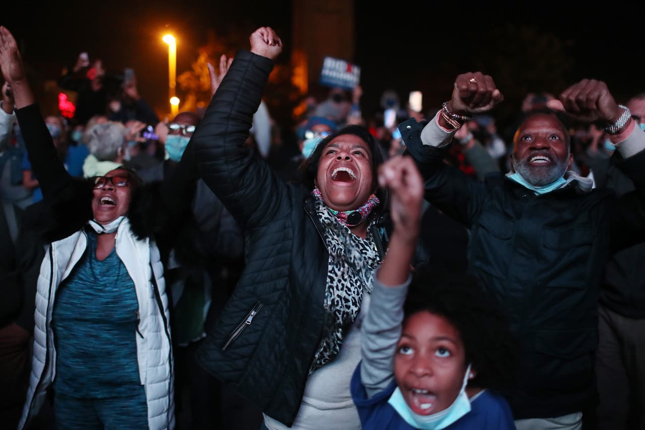 Jailyn Banks y King M, al centro de la imagen, reaccionan al momento en que el presidente electo Joe Biden entra al escenario en Delaware