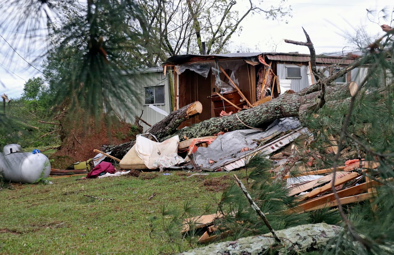 El tronco de un pino descansa sobre lo que queda de un remolque en Center Hill Road en las afueras de Hamilton, Mississippi, después de que una tormenta mortal arrasara el área.