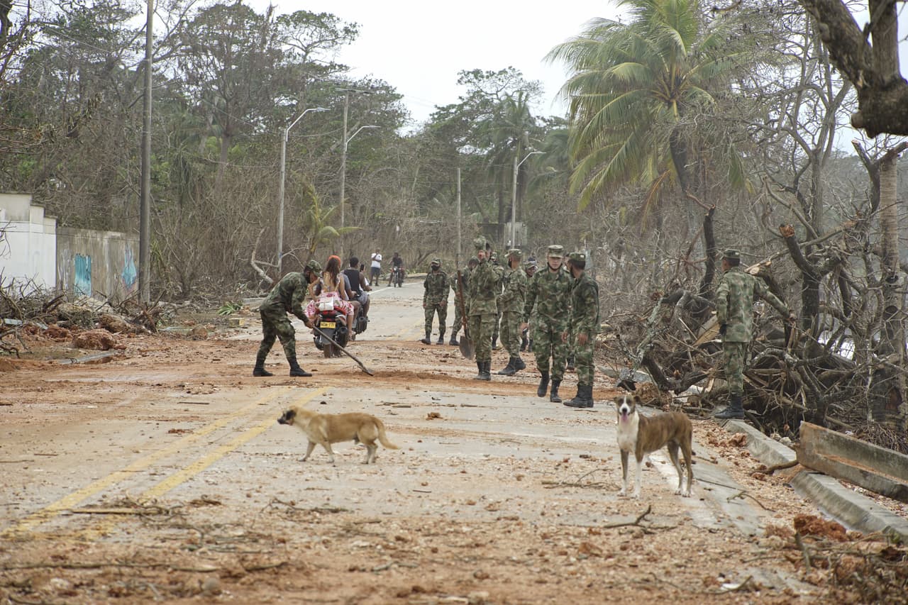 Soldados ayudan a despejar una carretera llena de escombros dejados por Iota a su paso por San Andrés. El mandatario colombiano afirmó que una persona continúa desaparecida, sin ahondar en más detalles.