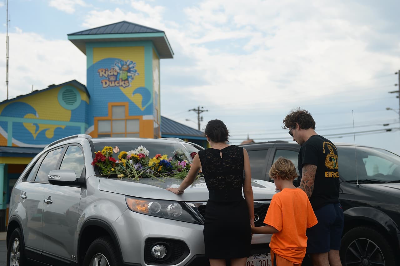 Una familia presenta sus respetos a los fallecidos. La empresa emitió un comunicado lamentando la tragedia y aseguró que la tormenta fue "inesperada", aunque los reportes meteorológicos advertían que las condiciones climáticas iban a empeorar en la tarde del jueves. (Michael Thomas/Getty Images)