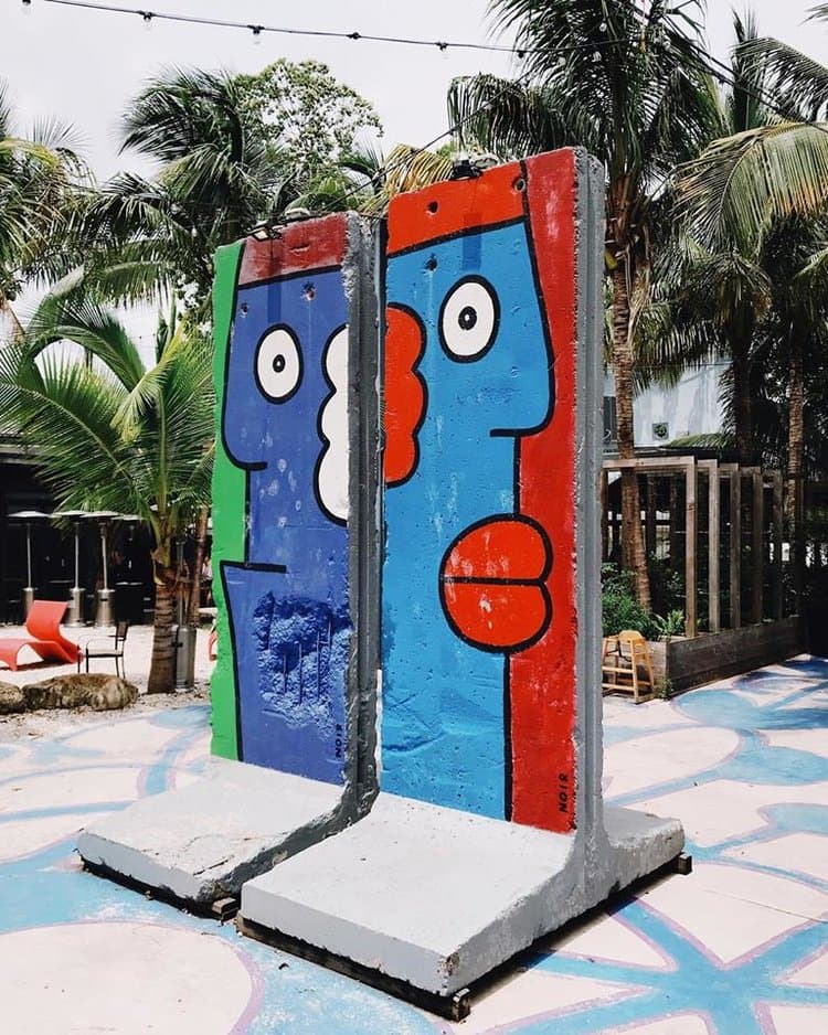 Florida también alberga pedazos de la histórica valla. Específicamente en el 
<b>Miami Ironside</b>, un vibrante centro urbano de más de 60 salas de exhibición de diseño, espacios para eventos, estudios emergentes, salas de juegos y galerías, se encuentran cuatro segmentos. 
<b>Los trozos originales fueron repintados </b>por el artista Thierry Noir durante la feria internacional ArtBasel 2013.