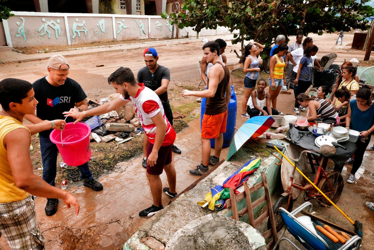 Gerardo Hernández (el segundo desde la izquierda, con camiseta negra) integrante de los llamados 'Los Cinco' trabaja junto con estudiantes cubanos para ayudar a limpiar la casa de una anciana tres días después del impacto del huracán Irma en La Habana. 'Los Cinco' son grupo de cubanos que estuvieron presos en EEUU bajo cargos de espionaje y conspiración entre otros cuya liberación se tornó una causa nacional para Cuba. 
<br>