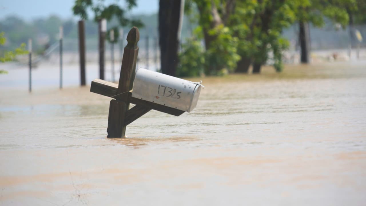 Un buzón está parcialmente sumergido en una calle inundada al este del condado de Harris, cerca de Houston, el domingo 5 de mayo de 2024 por la mañana.