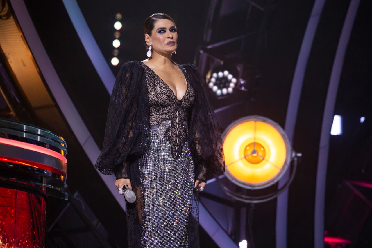 Gali llevó unos aretes discretos de doble platillo que hicieron juego con el brillo frontal del vestido.