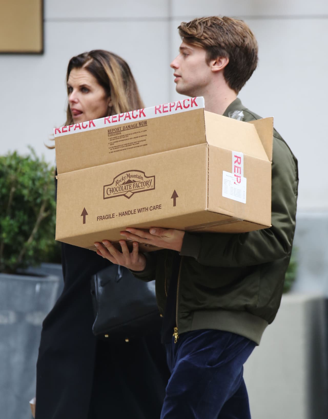 Durante el camino, el joven se encargó de llevar la caja que contenía los chocolates que compraron.