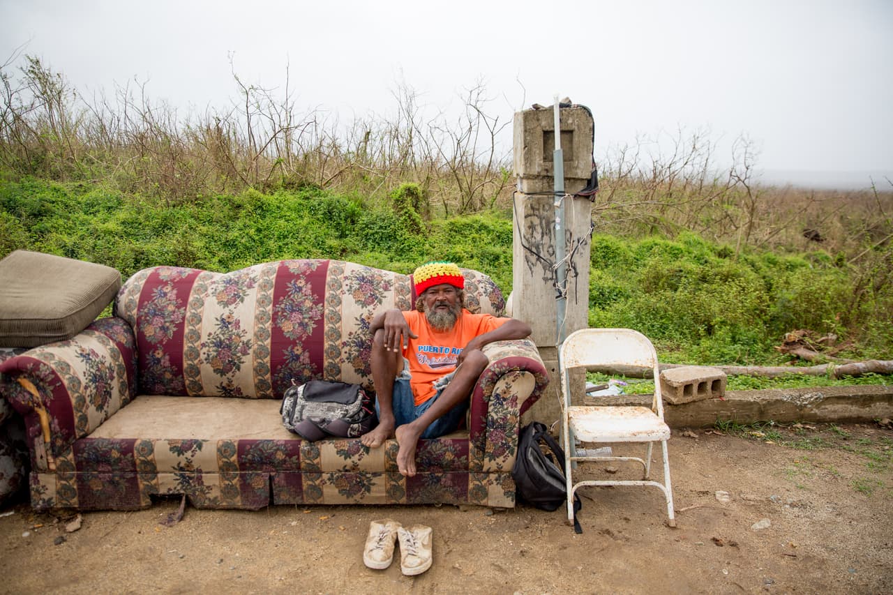 La fuerza de María derribó la casa de Alfredo Carmona, quien espera sentado frente a lo que antes fue un bosque verde. Luego del paso devastador del huracán que dejó a todos los árboles sin hojas y a merced del sol tropical, el reseco paisaje de Vieques parece haber sufrido un inmenso incendio forestal.