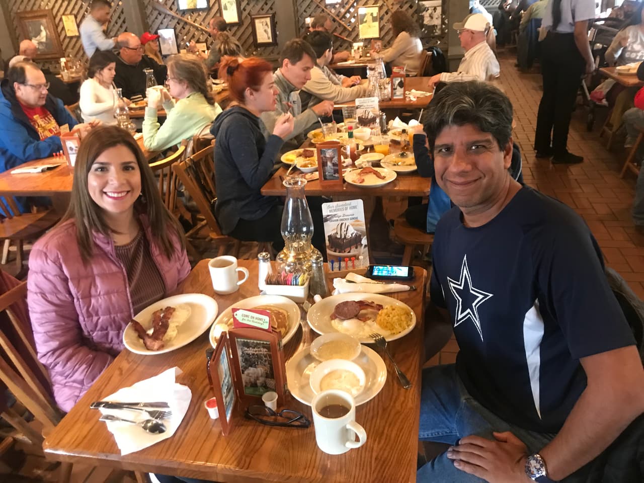 Karen Falla con su hermano Yuri de visita en Dallas tomando desayuno con la camiseta de los Cowboys.