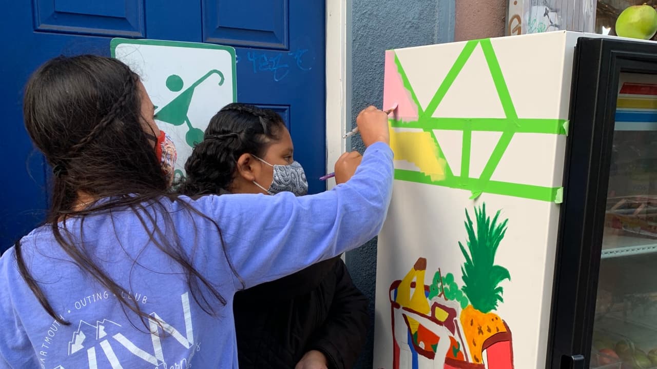 El proceso para pintar el refrigerador en la acera de la calle 24, en el barrio hispano de La Misión.