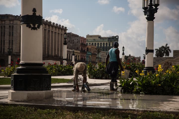 Dos personas hacen arreglos en la calle Prado.