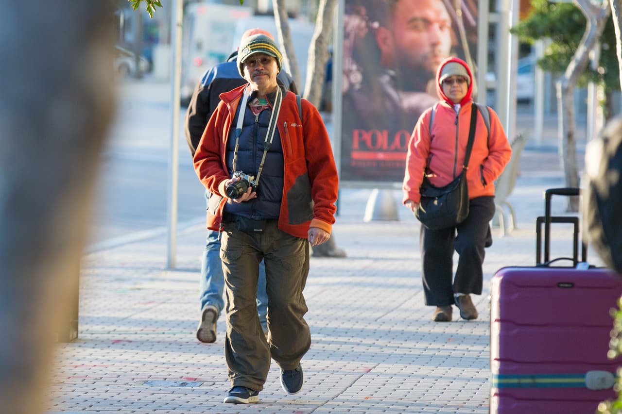 Algunos turistas en el Bayside de Miami recorren la ciudad vestidos con sacos y americanas.