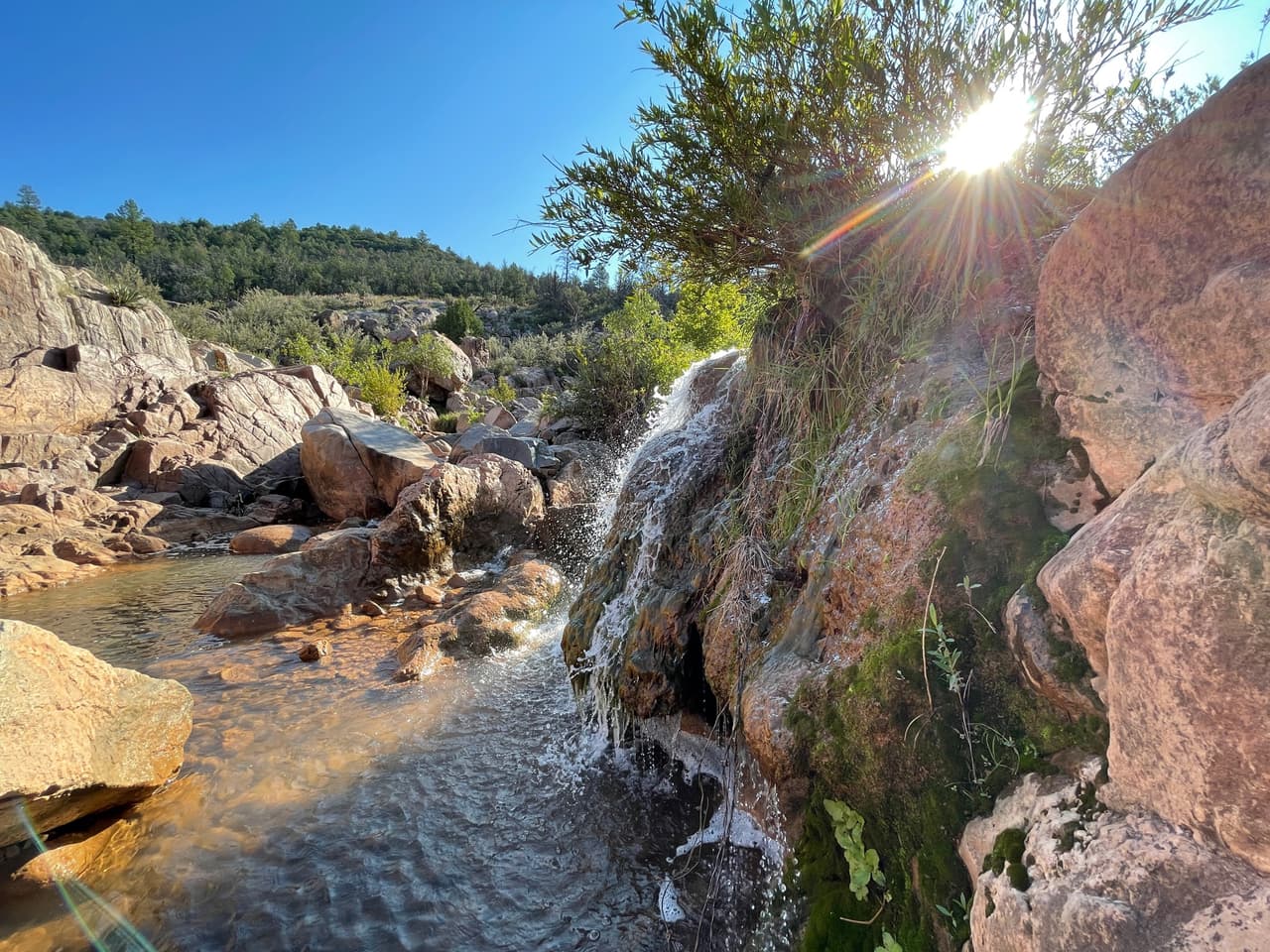 Un lindo sendero escondido que conduce a hermosas cascadas y piscinas de agua en las que puedes saltar y disfrutar.