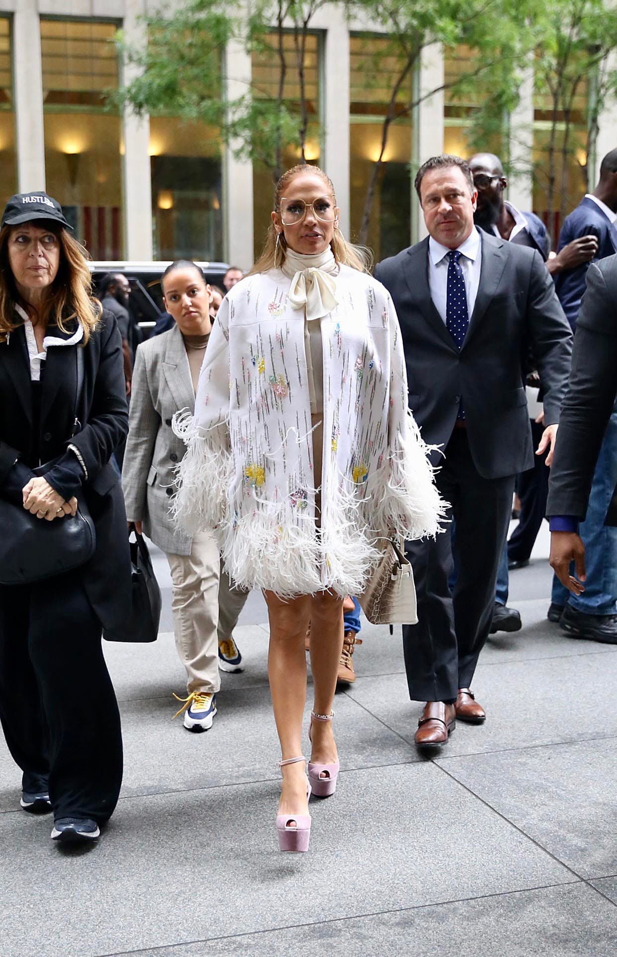<b>Look 10</b>
<br>Por la mañana arribó a Sirius XM enfundada en este 
<b><a href="https://www.modaoperandi.com/valentino-r20/bead-and-feather-embellished-jacket?ranMID=37385&ranEAID=2116208&ranSiteID=TnL5HPStwNw-4lMmlkMzhZaq4NzcLZ4Ilw&mid=37385&utm_source=rakuten_affiliate&utm_medium=Skimlinks.com&utm_campaign=conversion&utm_term=&siteID=TnL5HPStwNw-4lMmlkMzhZaq4NzcLZ4Ilw" target="_blank">poncho de plumas</a></b> y cuentas de Valentino ($14,895). Acompañó con 
<b><a href="https://www.gucci.com/us/en/pr/women/womens-accessories/womens-sunglasses/womens-sunglasses/womens-square-rectangle/oversize-round-frame-metal-glasses-p-506215I03308000" target="_blank">lentes de sol</a></b> Gucci ($650), 
<b><a href="https://www.marissacollections.com/shop/catalog/product/view/id/5032/s/4cm-rugiada-hoop-earrng-ljwr083-p-ci/?ranMID=36537&ranEAID=TnL5HPStwNw&ranSiteID=TnL5HPStwNw-4ThHK7UQPF4c7ZWw4ZSGJQ&siteID=TnL5HPStwNw-4ThHK7UQPF4c7ZWw4ZSGJQ" target="_blank">aretes</a></b> de Maria Cielo Rugiada ($3,100) y su bolso favorito: una 
<b><a href="https://madisonavenuecouture.com/products/hermes-white-matte-niloticus-himalayan-crocodile-birkin-30cm-1" target="_blank">Birkin Himalaya</a></b> de cocodrilo de Hermés ($150,000).