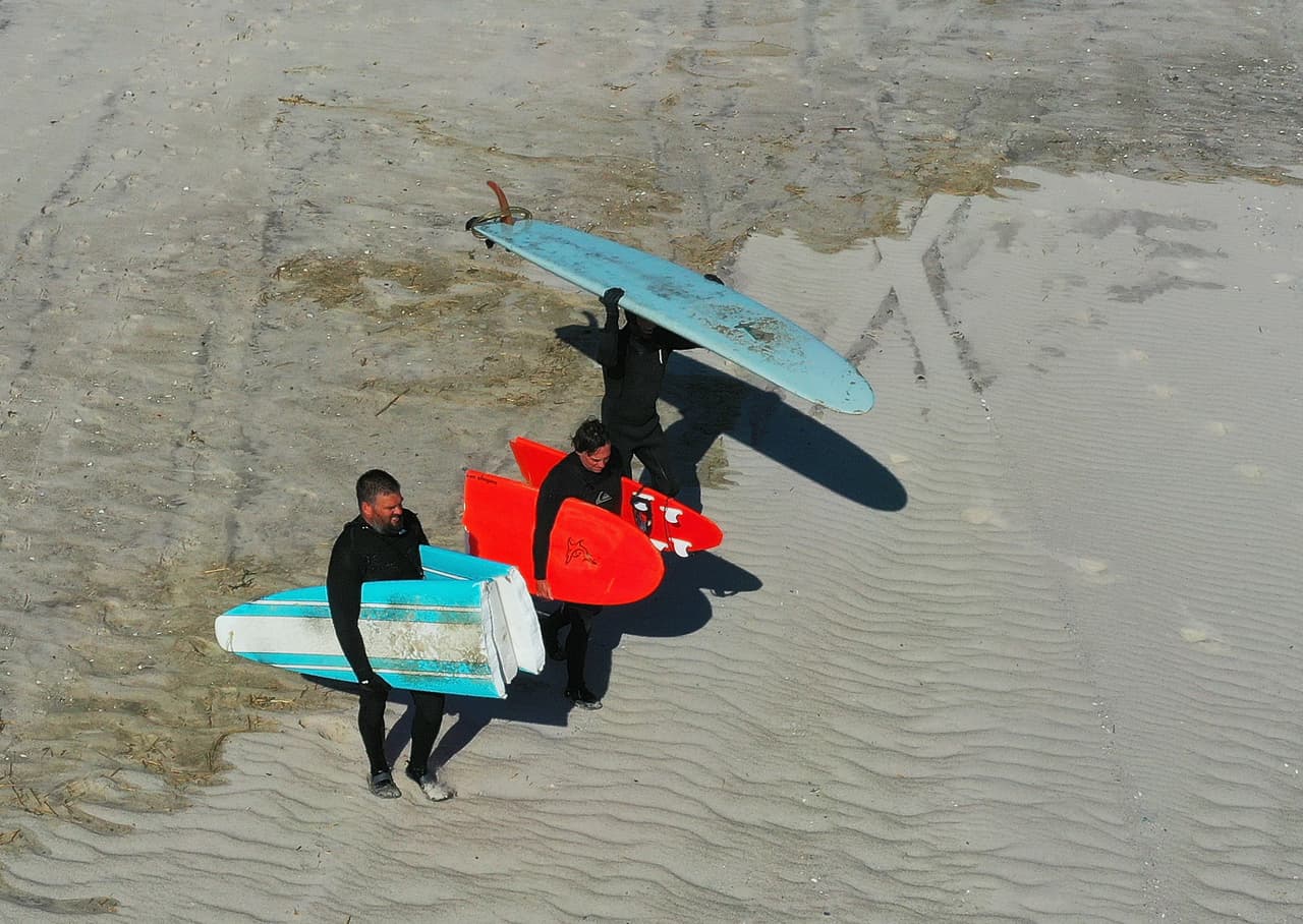 Una vista aérea desde un drone muestra a un grupo de surfistas que se dirigen al mar en Long Beach, a pocas horas de su reapertura en la madrugada del miércoles.