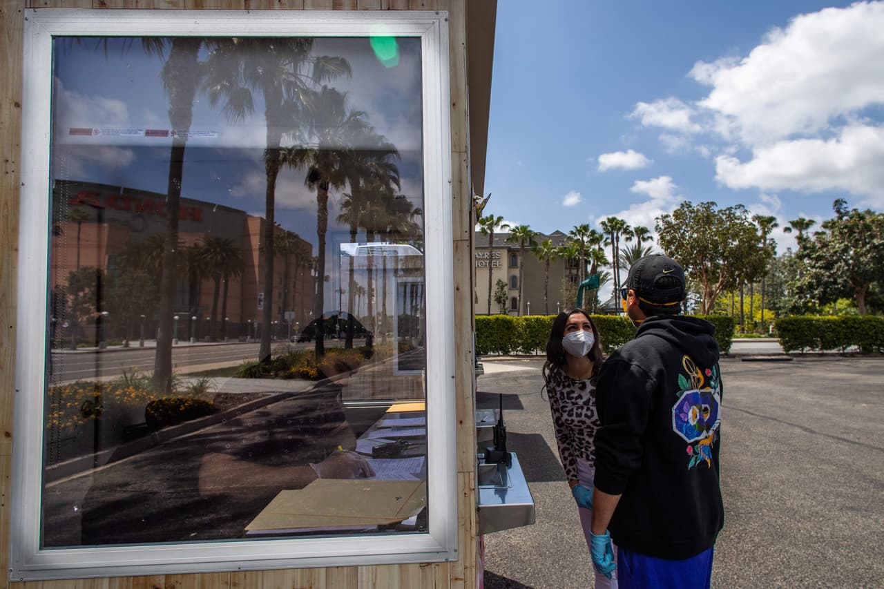 <b>Lo que importa es el amor.</b> Joana y Andrew usan máscaras durante la ceremonia de su boda oficiada por un secretario en el estacionamiento del Honda Center en Anaheim, California. Aunque no llegaron con un atuendo demasiado elegante, a esta pareja lo que le interesaba era expresar su amor ante la ley, pero eso sí, cuidando todas las medidas de seguridad necesarias, por lo que usaron mascarillas y guantes de látex. El número total de bodas en 2019 en Orange fue de 24,290, según el sitio The Wedding Report.