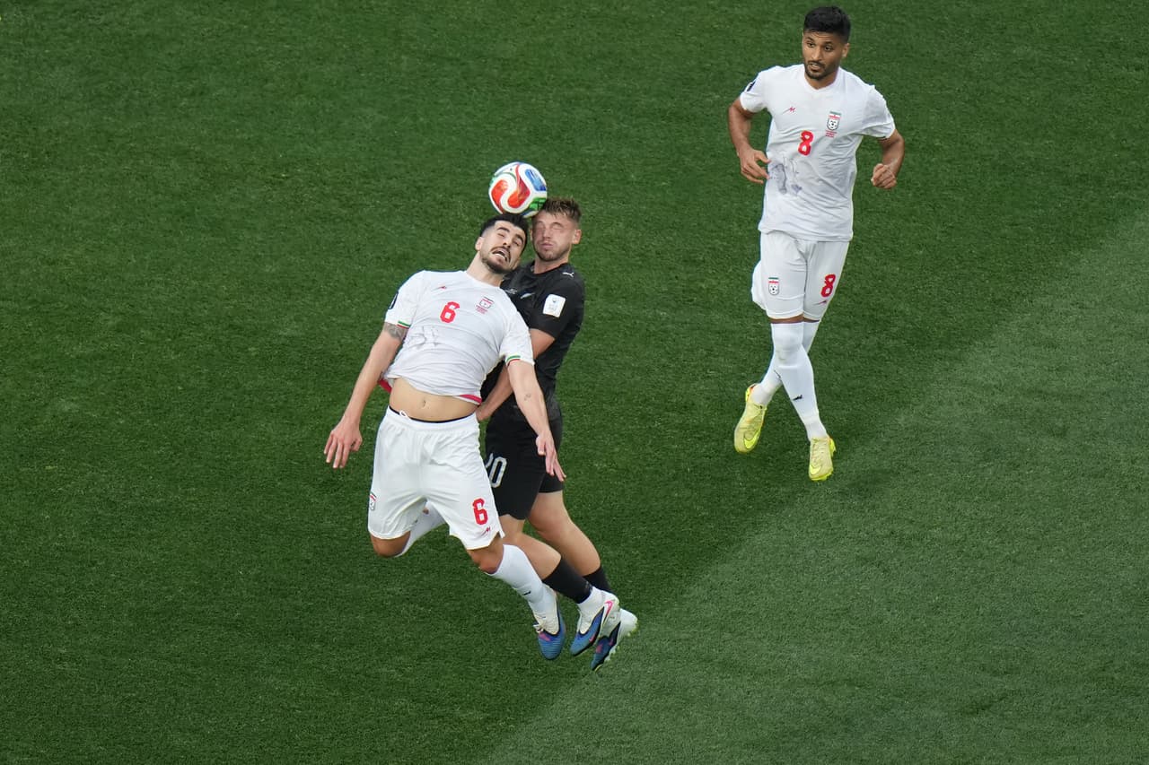 El iraní Saeid Ezatolahi (6) disputa el balón con el neozelandés Callum McCowatt (20) durante el partido de fútbol del Grupo G de la Copa del Mundo entre Irán y Nueva Zelanda en Inglewood.