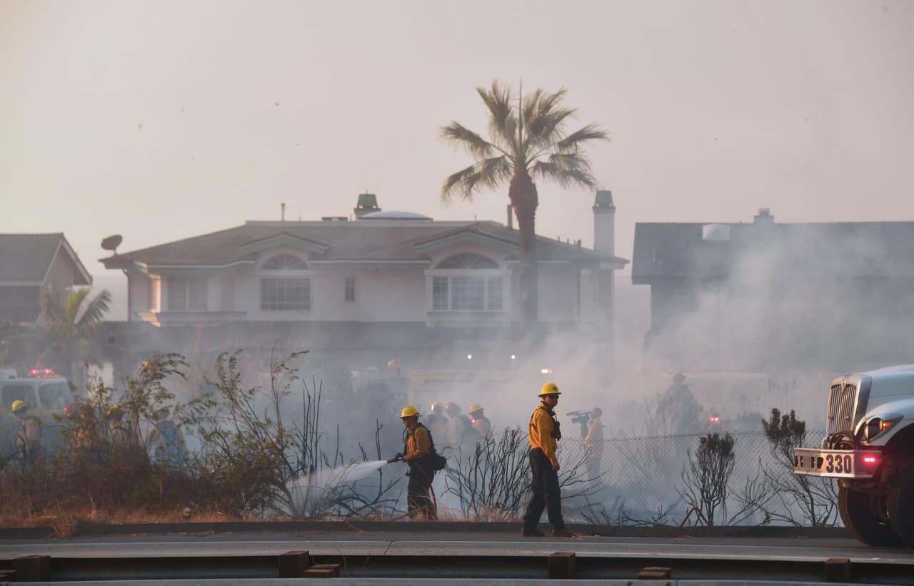 Los bomberos luchan contra el fuego al sur de la autopista 101 en Mondos Beach, al oeste del condado de Ventura. Los vientos Santa Ana continúan avivando el fuego al sur del estado.