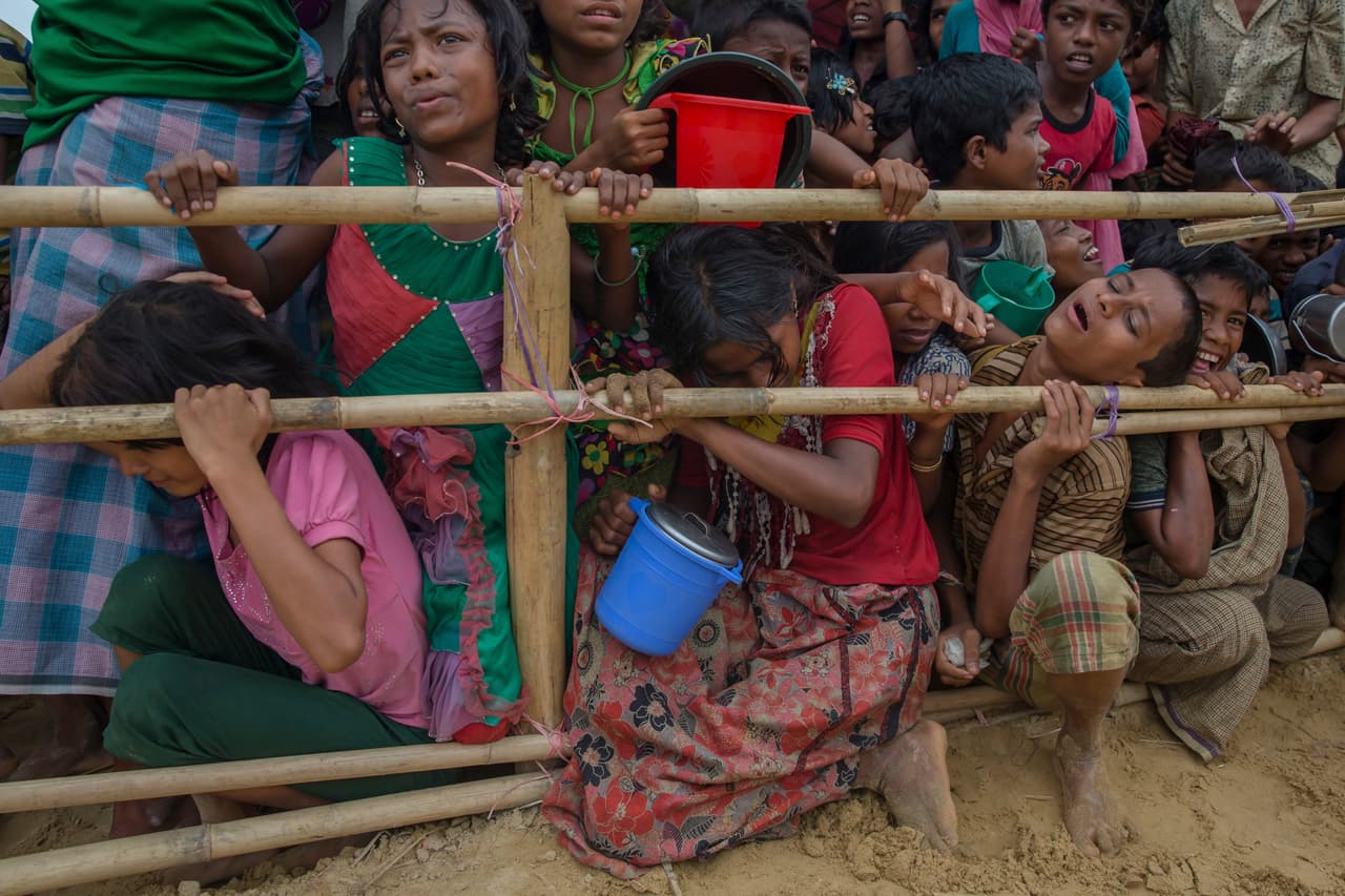 El cólera y la desnutrición son los principales padecimientos de los niños refugiados rohingya. En la fotografía, decenas de niños apiñados esperan por una ración de comida distribuida por una ONG en Thaingkhali, Bangladesh.
<br>