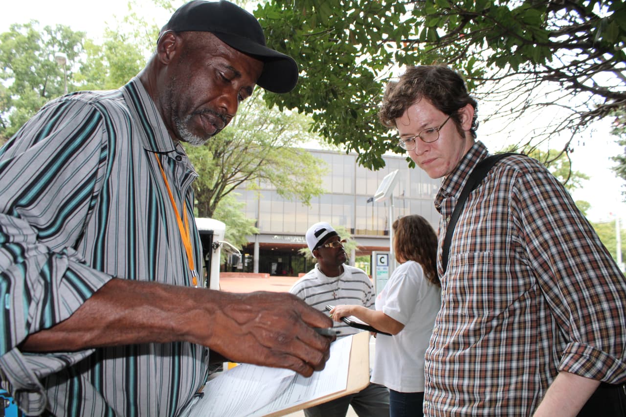 Muhammad Abdul-Rahman ayuda a un joven a registrarse para votar.