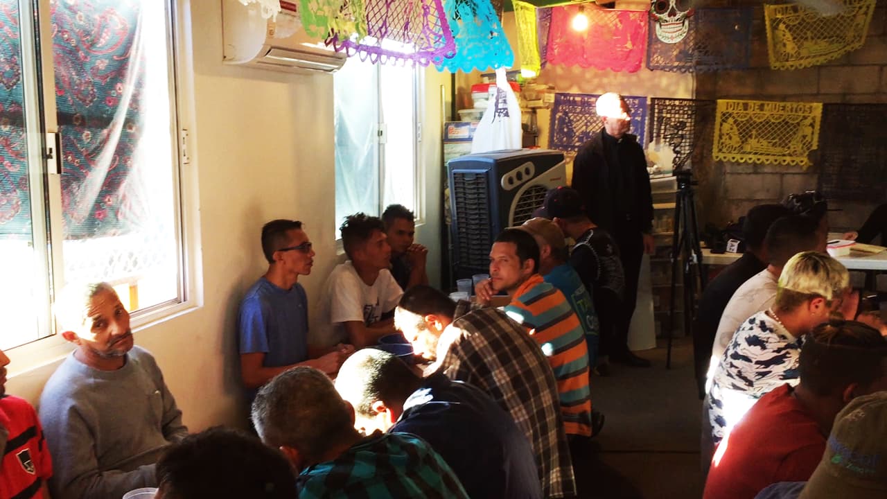 Algunos migrantes que se quedan en Nogales por días mientras definen el camino a seguir se alimentan en este centro.