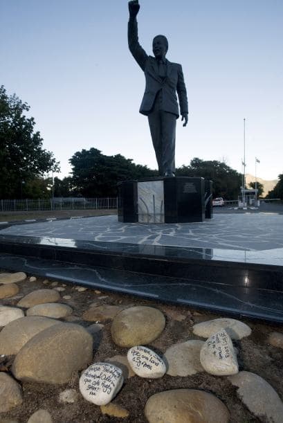Seguidores de Mandela colocaron piedras con mensajes de apoyo frente de una estatua de Nelson Mandela ubicada ante la prisión de Drakenstein, cerca de Paarl, a unos 75 kilómetros de Ciudad del Cabo.