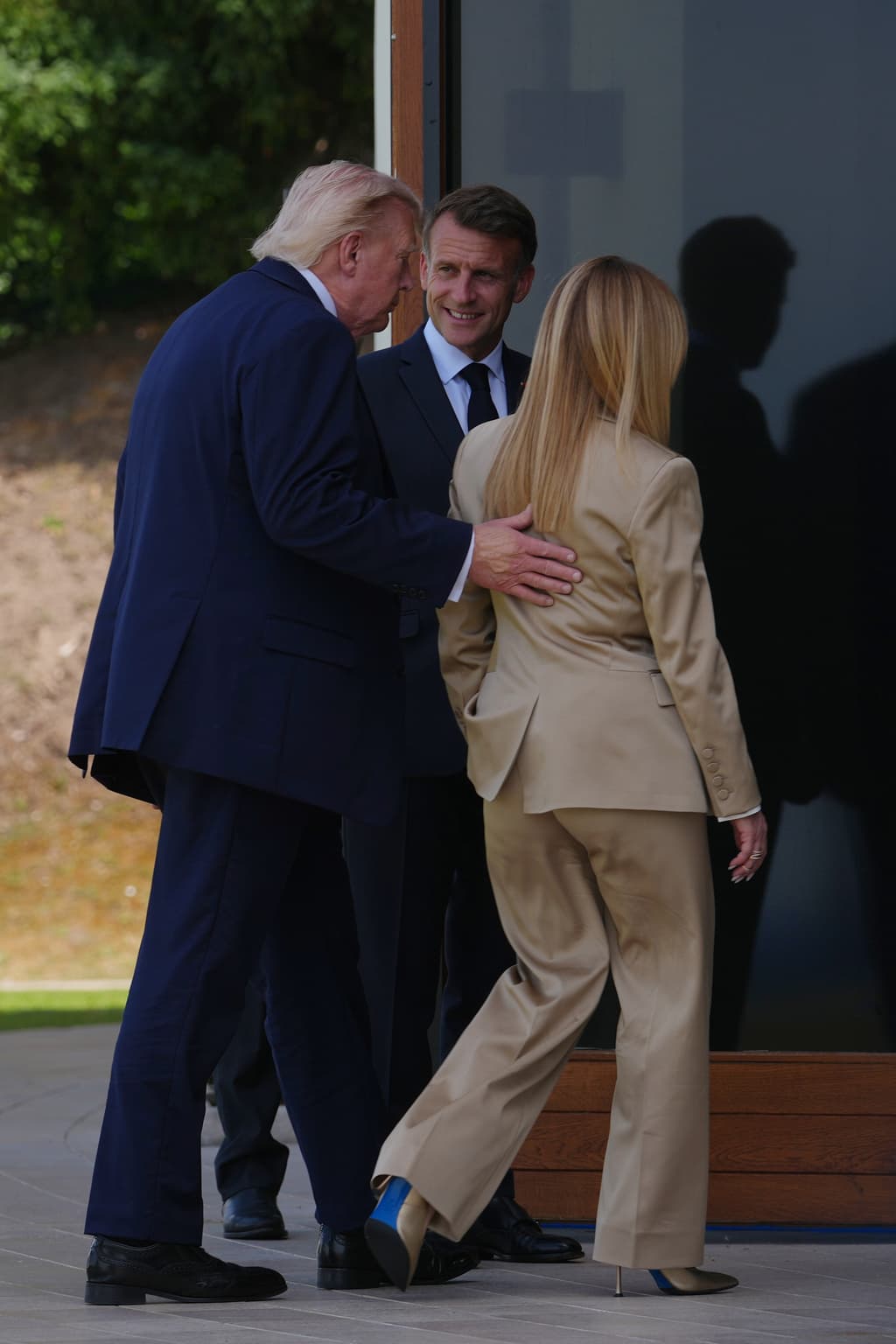 El presidente de Estados Unidos, Donald Trump (izquierda), conversa con el presidente francés, Emmanuel Macron (centro), y la primera ministra italiana, Giorgia Meloni, tras la foto de grupo de los líderes del G7 y de las naciones invitadas durante la cumbre del G7 en Evian-les-Bains, Francia, el martes 16 de junio de 2026. (Foto AP/Thibault Camus)
