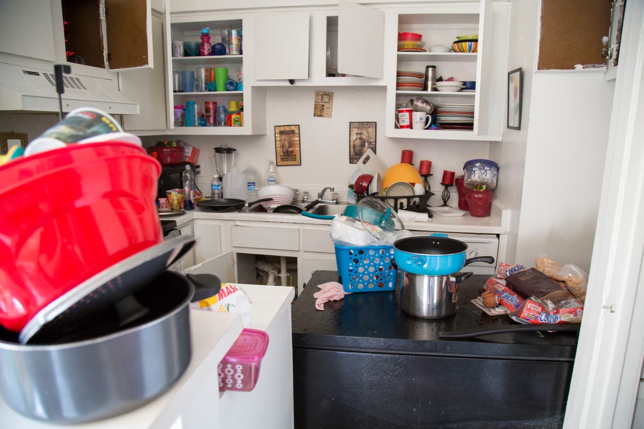 El refrigerador de este apartamento fue derribado por el agua que inundó todo el primer piso. La inquilina del lugar trata de sacar al menos los utensilios de cocina.