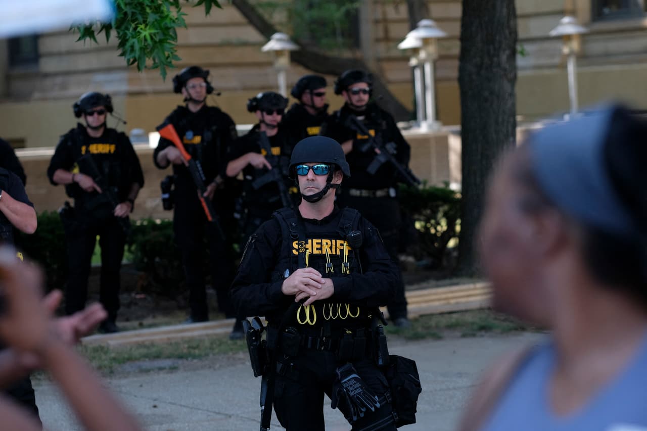 Miembros del departamento del sheriff con equipo antidisturbios esperan mientras los manifestantes se reúnen frente al Ayuntamiento de Akron para protestar por el asesinato de Jayland Walker. Las imágenes
<b> </b>muestran que pudo haber recibido hasta 90 balas, debido a la cantidad de rondas que fueron disparadas en su contra.