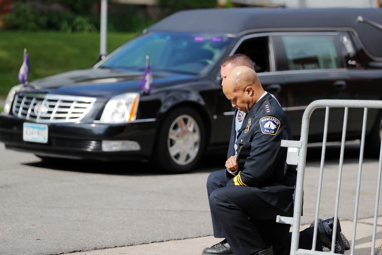 Dos policías, incluyendo el jefe policial de Minneapolis, Medaria Arradondo, hincan sus rodillas al pasar el féretro de George Floyd.