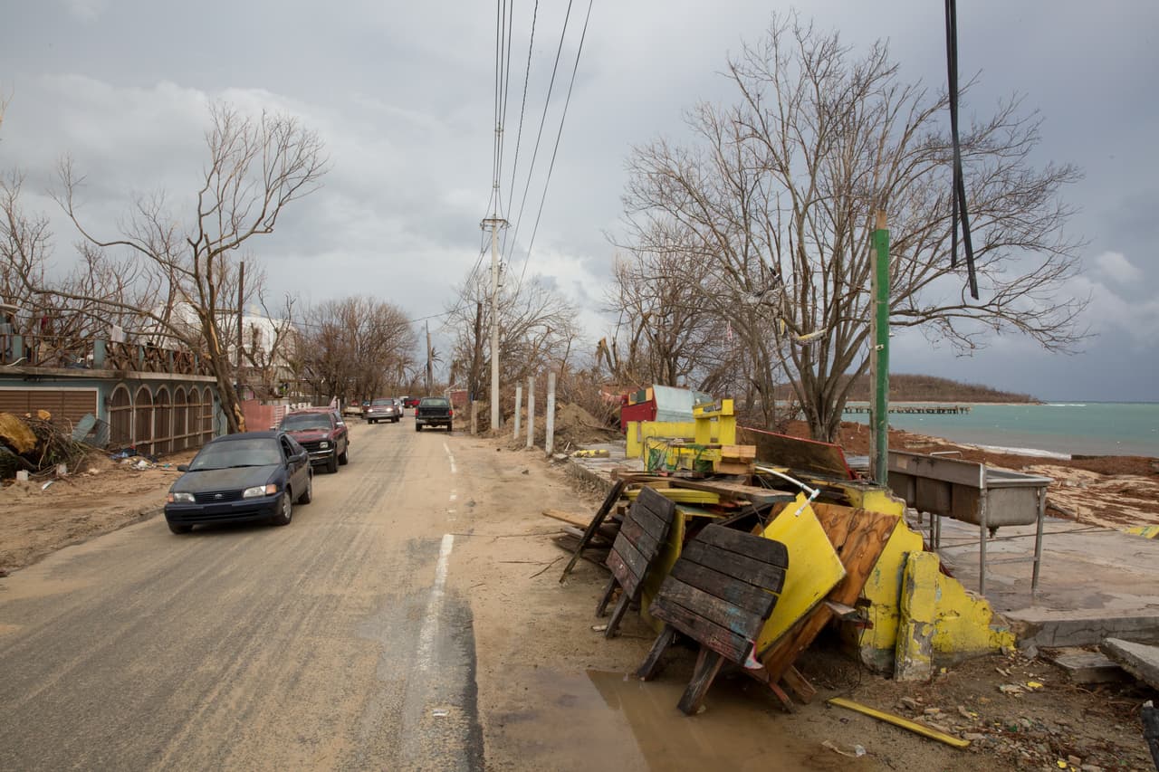 La marea ciclónica empujó el mar hacia adentro de los restaurantes de playa Esperanza y parte del malecón resultó derribado. La comunidad se organizó para retirar los escombros de la vía, aún cubierta por la arena de la playa.