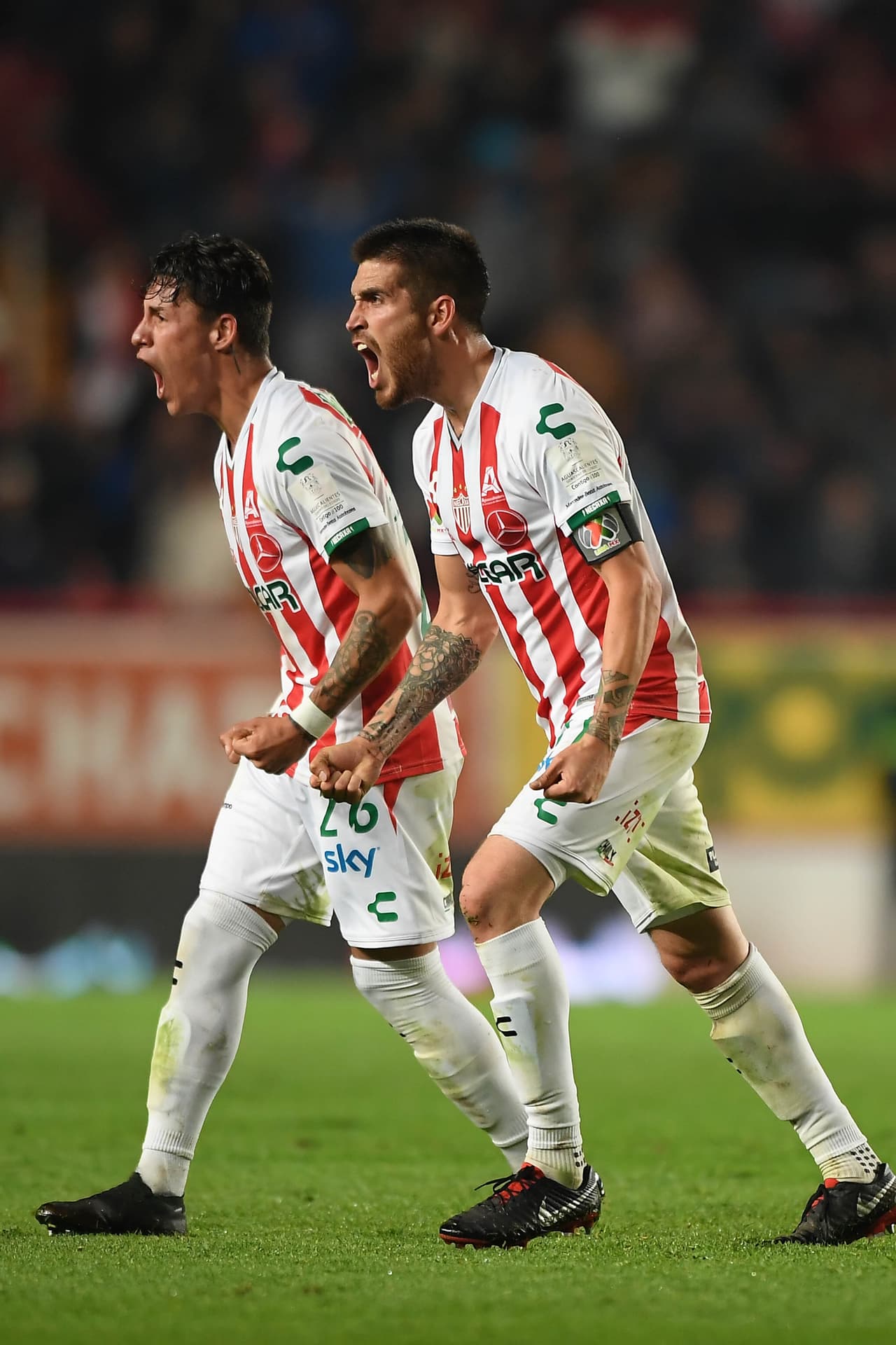 Ventura Alvarado y Cristian Calderon del Necaxa lucen sus tatuajes durante el festejo.