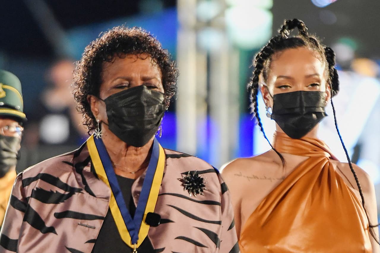 Rihanna junto a la nueva presidenta de Barbados, Sandra Mason. En el acto, la primera ministra barbadense Mia Mottley recalcó los orígenes humildes de la cantante y la felicitó por “dominar la imaginación del mundo”. 
<br>
<br>Elogió “su extraordinario compromiso con la tierra de su nacimiento” y le dijo “que continúe brillando como un diamante”.