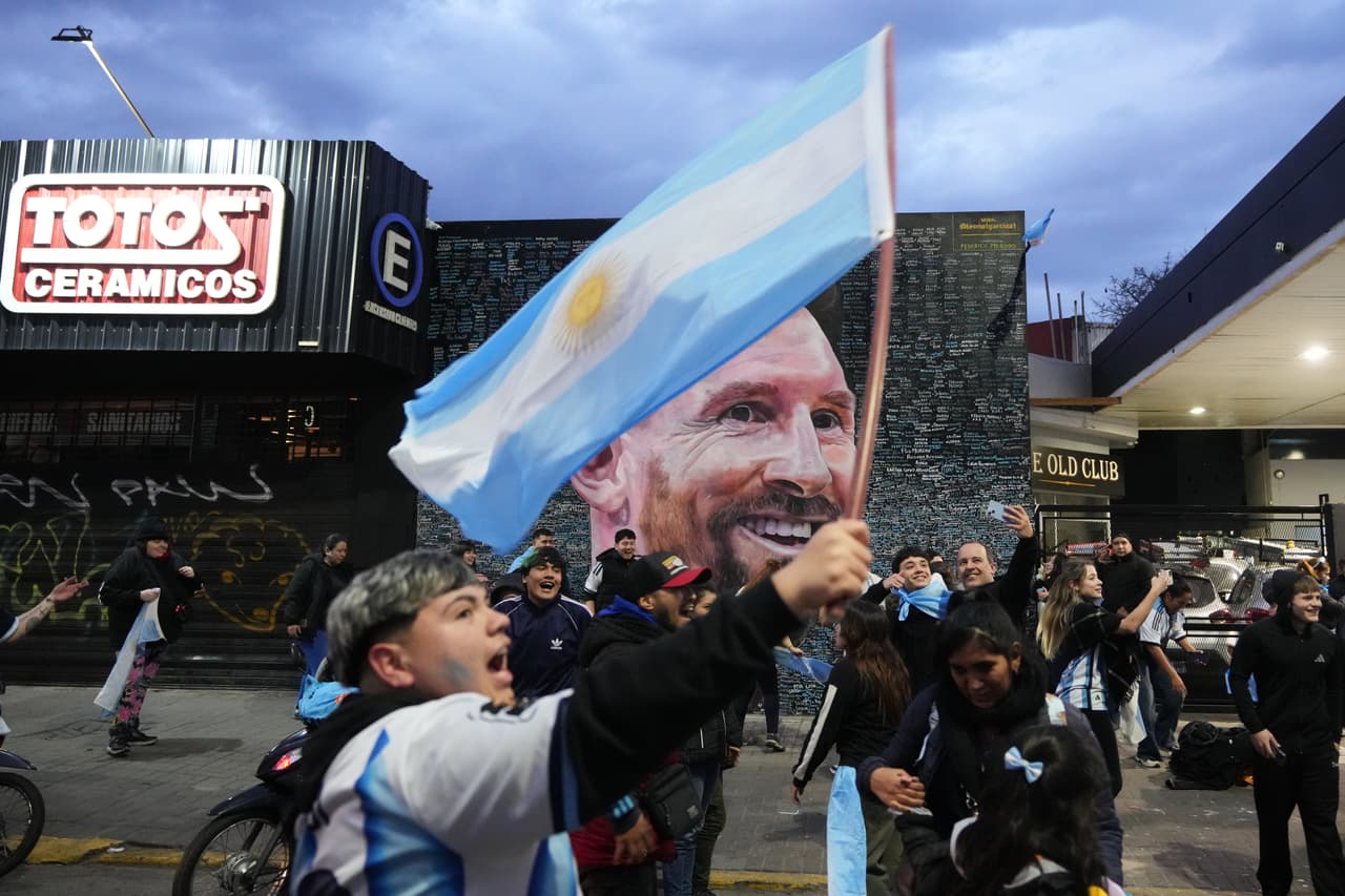 Aficionados celebran frente a un mural de Lionel Messi después de que Argentina derrotara a Inglaterra en el partido de semifinales de la Copa del Mundo de fútbol, en Buenos Aires, Argentina, el miércoles 15 de julio de 2026.