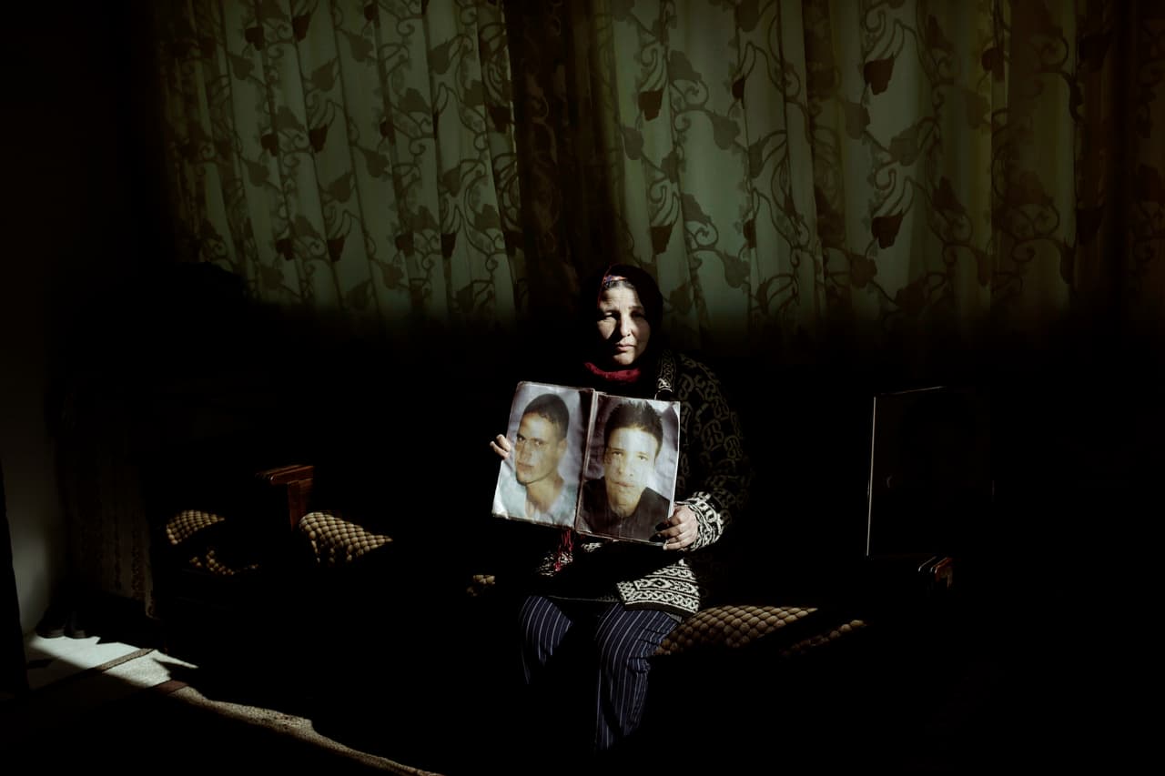 Fathia Jejli sostiene una foto de su hijo, Hossam Edin Jejli, a la derecha, y su sobrino, Hamed Ben Brayek, quien desapareció en 2011, en su casa en la ciudad de Ras Jabal, Bizerte, Túnez. (AP Photo / Nariman El-Mofty)