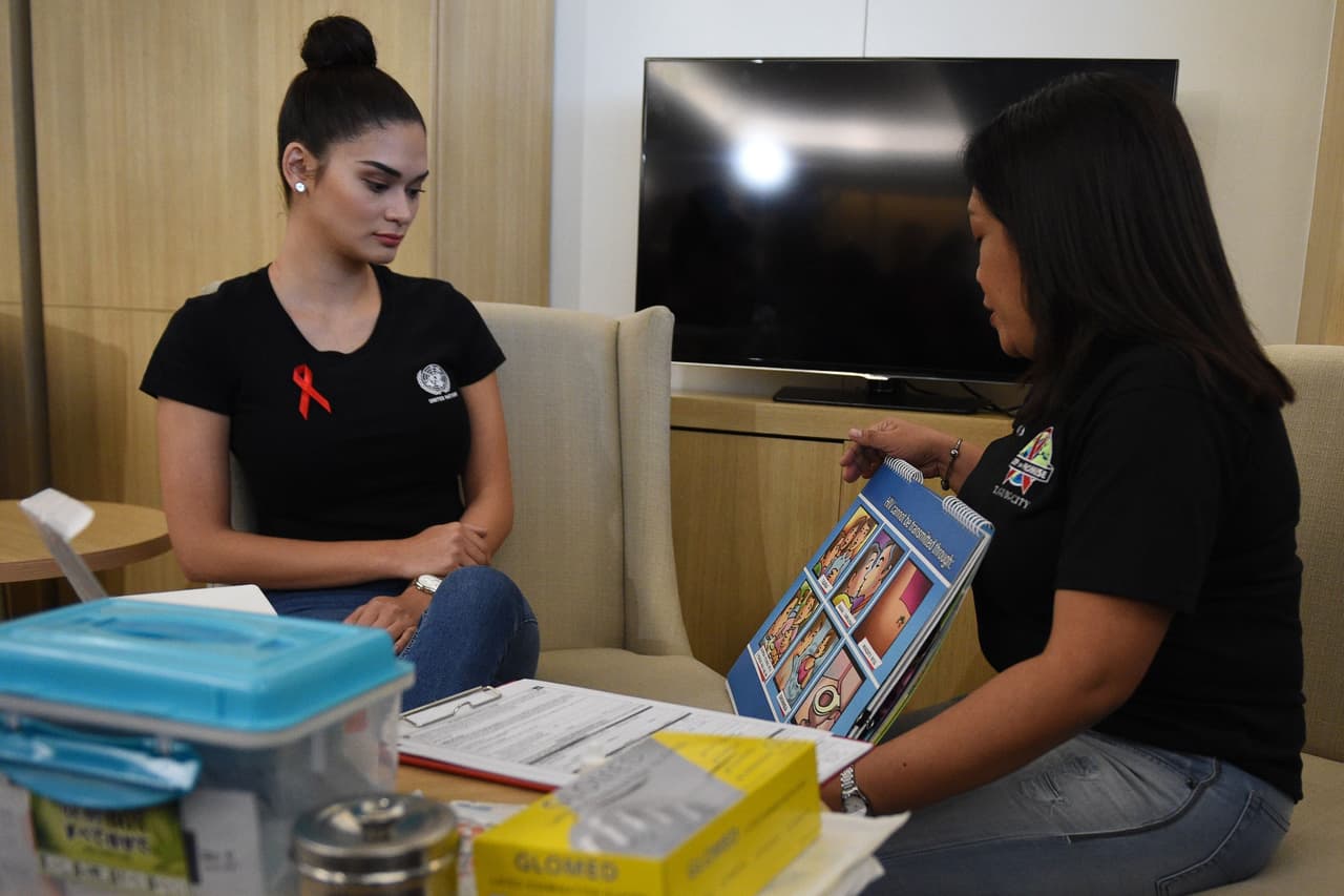 Pia Wurtzbach (L), The Philippines' former Miss Universe and UNAIDS goodwill ambassador for Asia, listens to a medical worker giving counselling prior to extracting her blood sample for an HIV test at a government office in Taguig City, suburban Manila on August 9, 2017, as part of her advocacy to raise awareness on HIV. The Philippines' former Miss Universe conducted a public HIV test in Manila on August 9, a week after the United Nations said her country had the fastest growing number of infections in Asia. / AFP PHOTO / TED ALJIBE / The erroneous mention[s] appearing in the metadata of this photo by TED ALJIBE has been modified in AFP systems in the following manner: [Pia Wurtzbach] instead of [Pia Wurtzbuck]. Please immediately remove the erroneous mention[s] from all your online services and delete it (them) from your servers. If you have been authorized by AFP to distribute it (them) to third parties, please ensure that the same actions are carried out by them. Failure to promptly comply with these instructions will entail liability on your part for any continued or post notification usage. Therefore we thank you very much for all your attention and prompt action. We are sorry for the inconvenience this notification may cause and remain at your disposal for any further information you may require. (Photo credit should read TED ALJIBE/AFP/Getty Images)