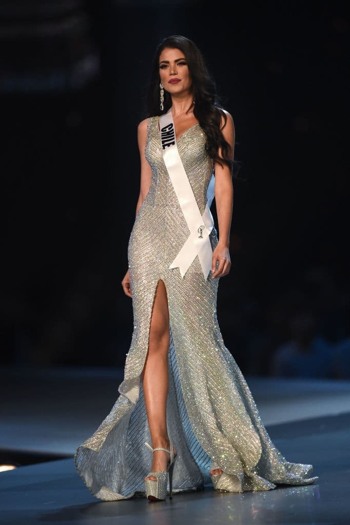 Originaria de Chile, Andrea Díaz concursó en Miss Universo en 2018, cuando el evento se llevó a cabo al otro lado del planeta: en Bangkok, Tailandia. La modelo y periodista apostó por un vestido plateado lleno de aplicaciones brillantes y aunque no ganó la competencia sí fue una de las mejores vestidas.