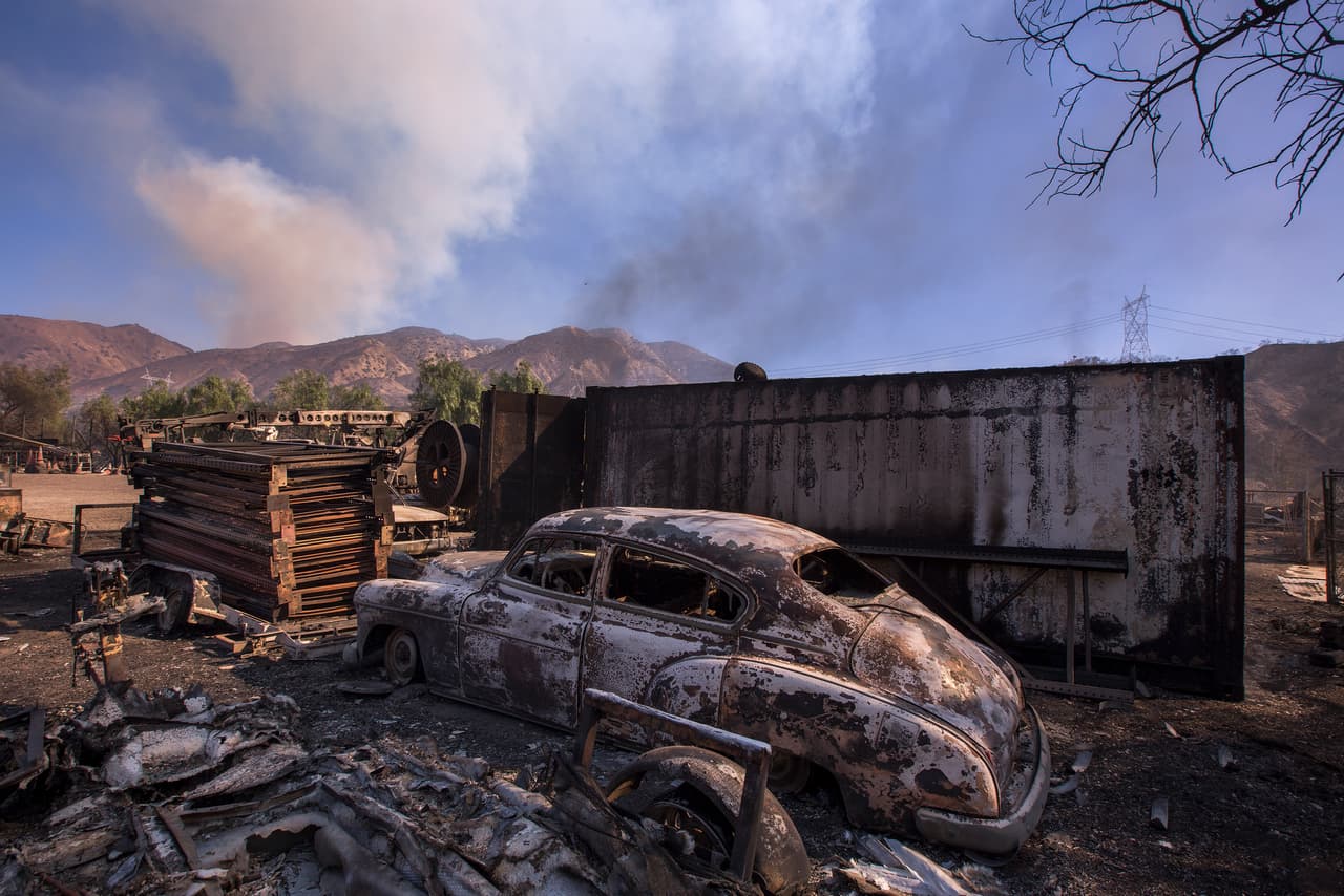 Un auto antiguo quemado en Sylmar, al norte de Los Ángeles. Decenas de escuelas también cerraron en el condado vecino de Ventura, donde el incendio más grande de la zona ha carbonizado más de 38.000 hectáreas.