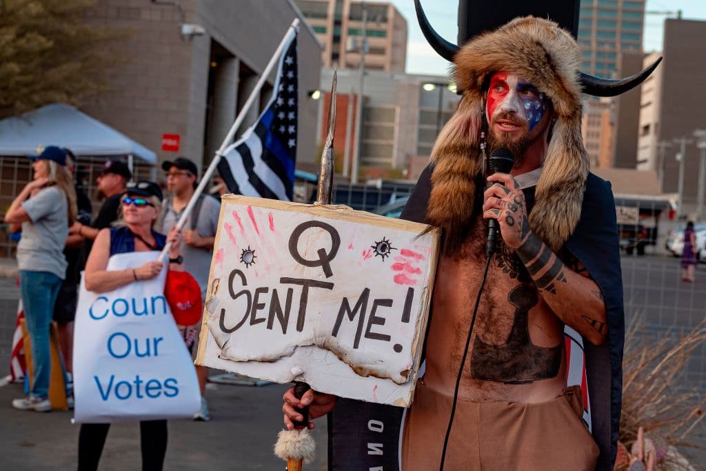 Este seguidor de QAnon, conocido como el 'Lobo de Yellowstone', mostraba un cartel que decía "Q me envío" mientras se manifestaba junto a simpatizantes de Trump frente a la oficina electoral en Arizona el jueves.