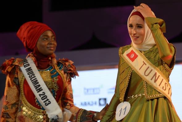 Fatma toca la corona entregada por Obabiyi Aishah Ajibola, de Nigeria, la Miss Musulmana del año anterior.