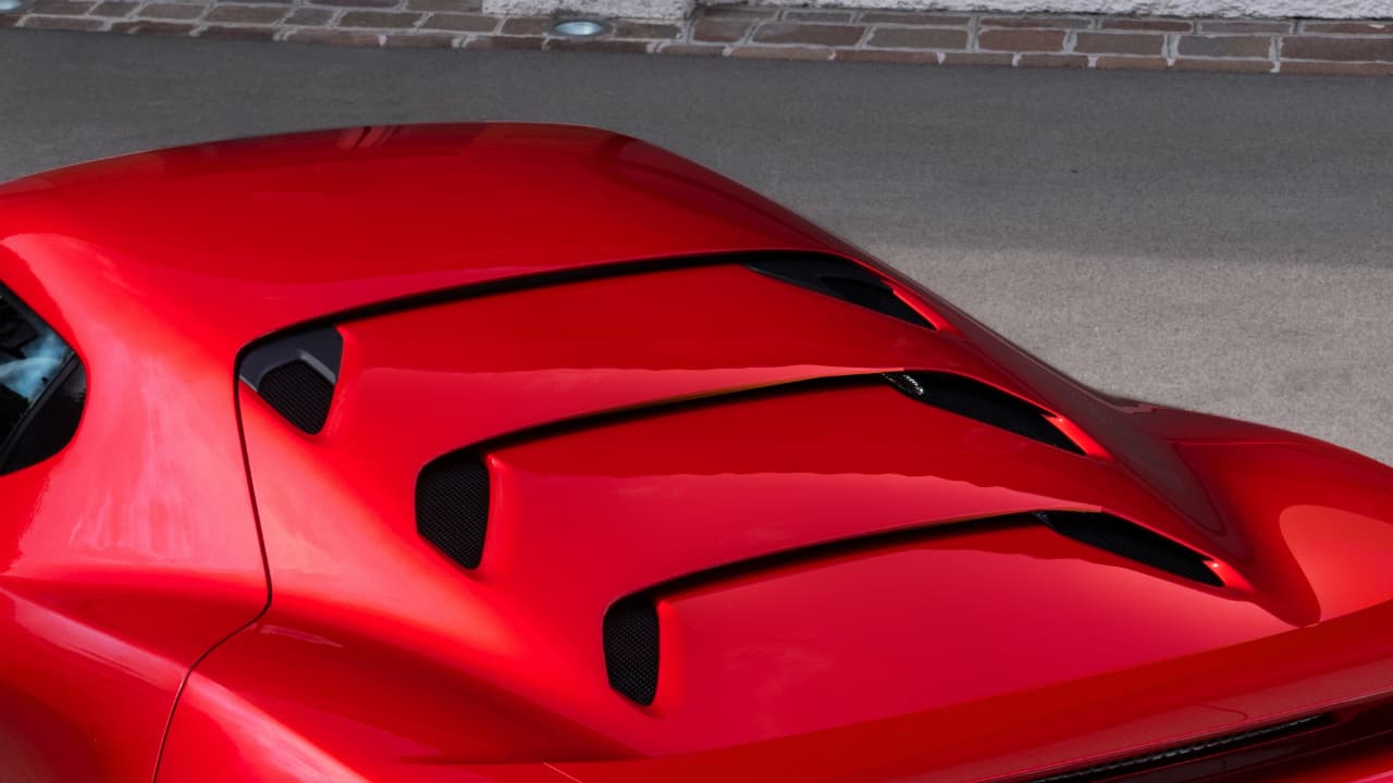 La cubierta del motor en esta ocasión no es transparente. Su tapa está compuesta por varios pliegues fabricados en fibra de carbono, que sirven para ventilar y enfriar el área del motor