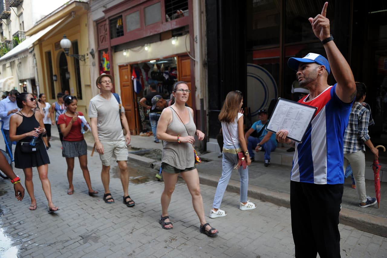 Tourists walk along a street of Havana, on June 15, 2017. / AFP PHOTO / YAMIL LAGE (Photo credit should read YAMIL LAGE/AFP/Getty Images)