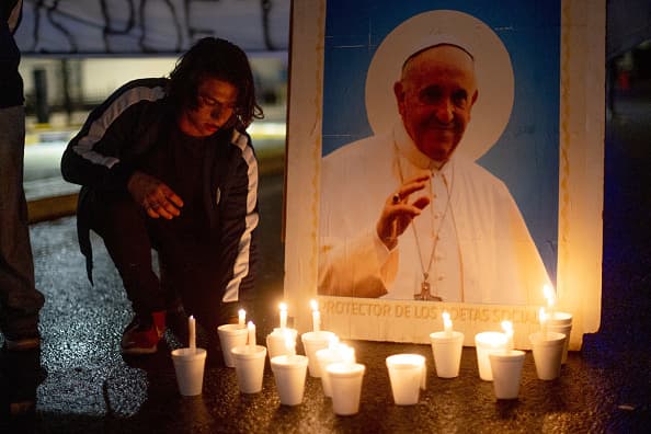 Una foto del papa Francisco con velas para honrarlo a las afueras de la basílica de Buenos Aires.