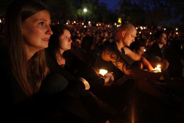 La luz de las velas ilumina los rostros de los estudiantes durante la vigilia.