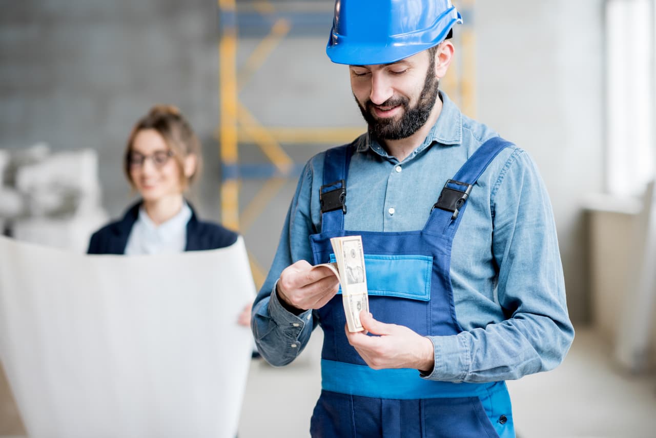 Albañil con su paga en dólares.