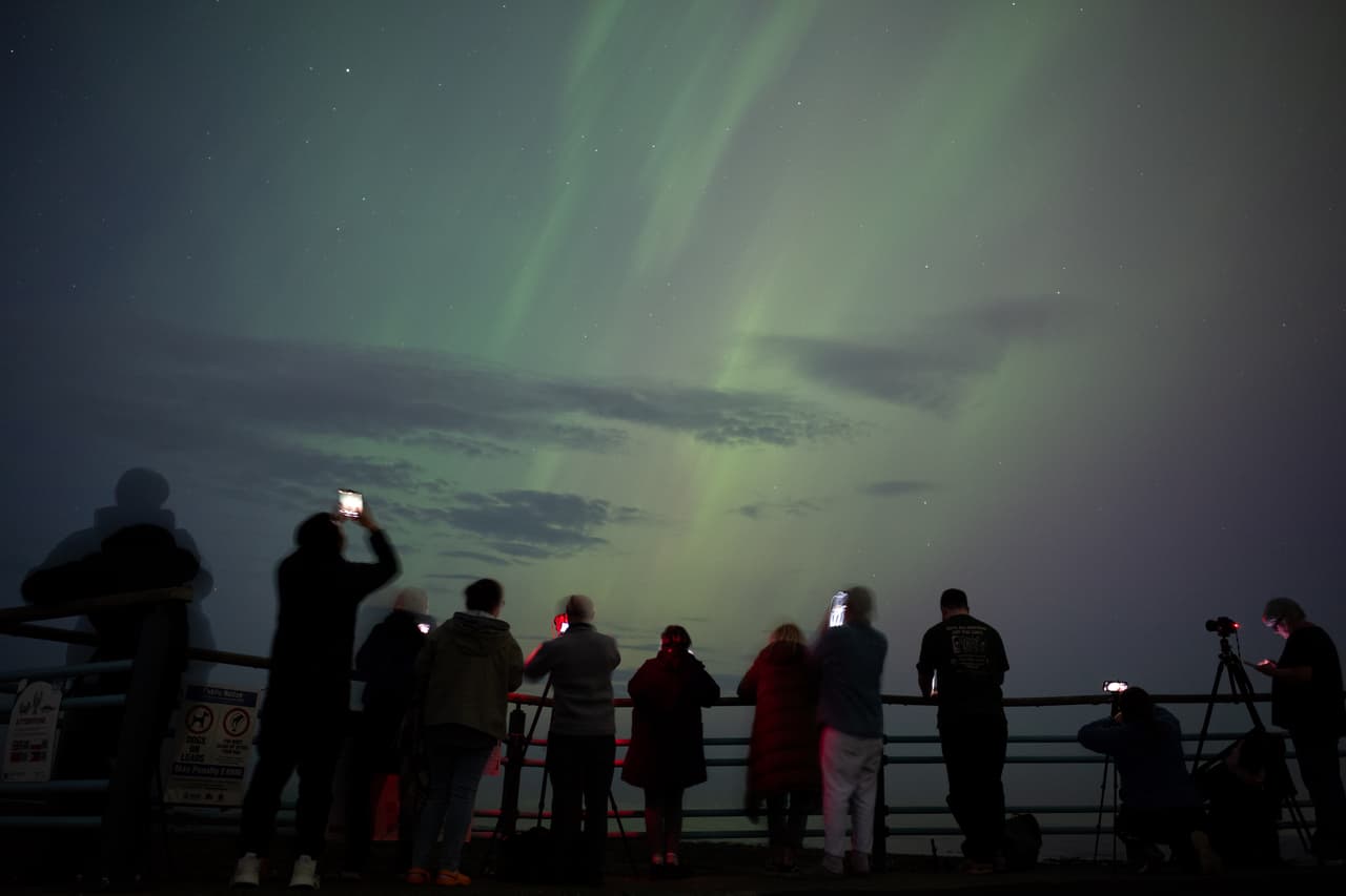 La gente visita el faro de St Mary en Whitley Bay, Reino Unido, para ver la aurora boreal.