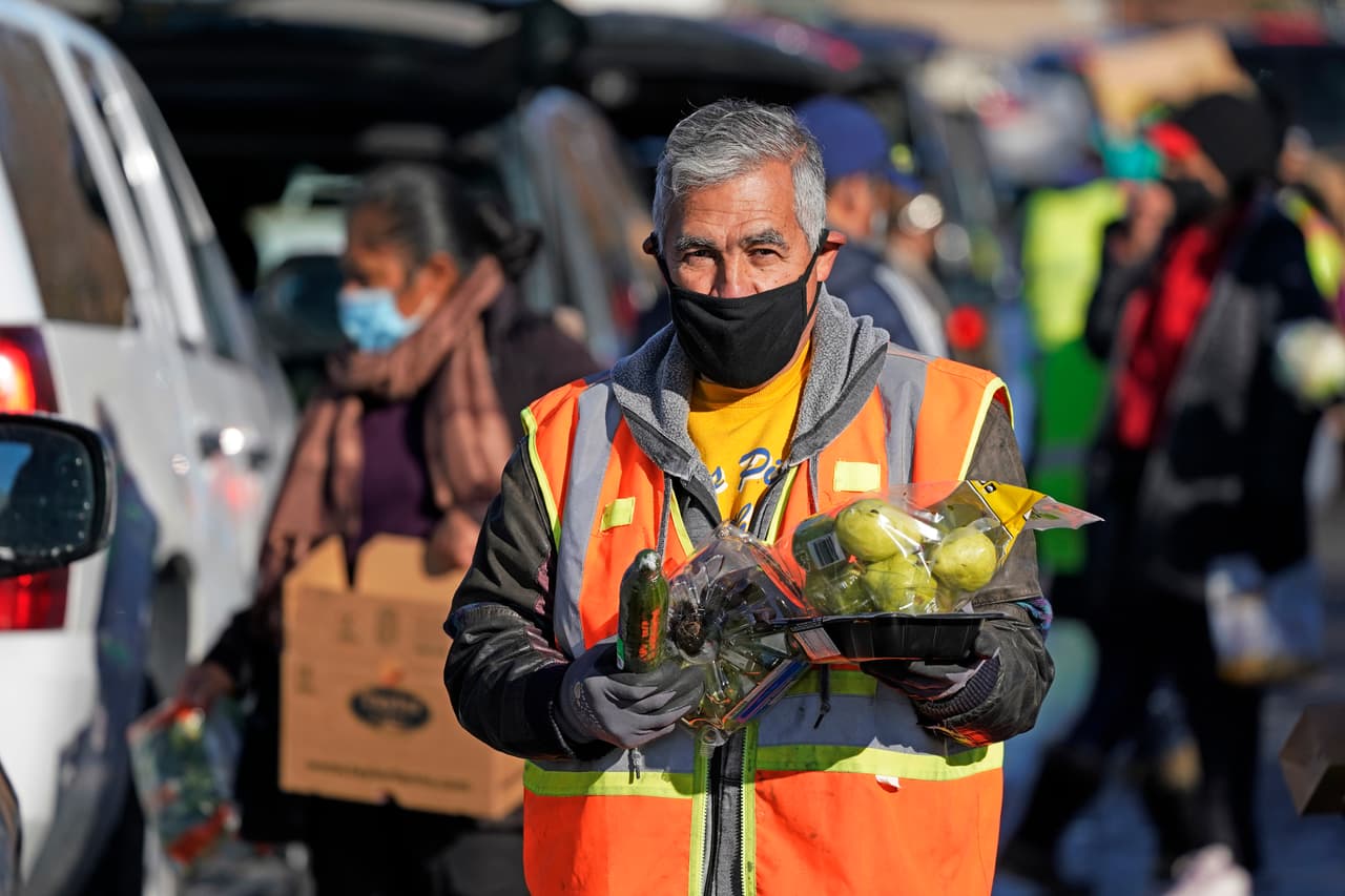 Un voluntario ayuda con la distribución de los alimentos en West Valley City, Utah. CityTeam, una organización benéfica de Santa Clara, California, informó que las familias necesitadas aumentaron de 1,400 en el mes en febrero a 4,400 en noviembre.